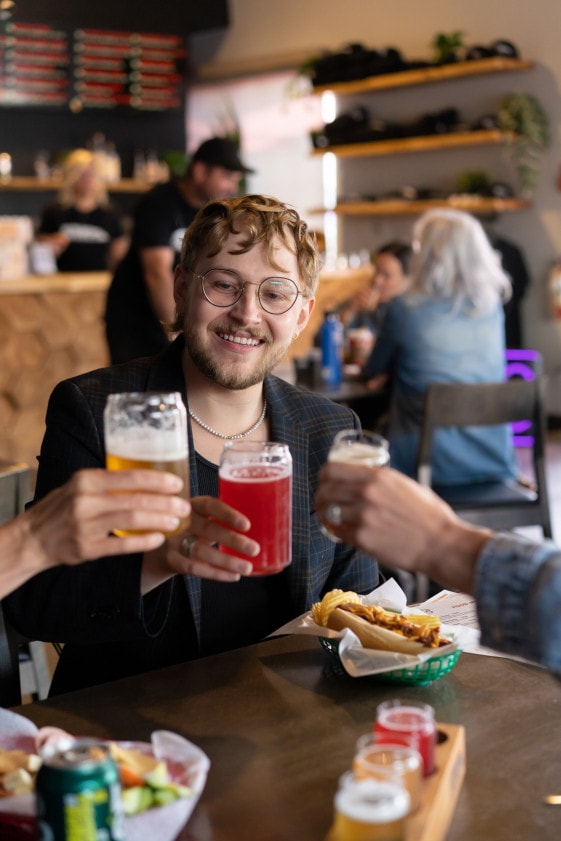 a group lifts their glasses in a cheers at Ricochet Brewing & Taphouse in Salmon Arm, BC